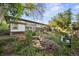 Exterior of home in backyard, featuring lush landscaping, shed, and partially covered patio at 5054 W 61St Dr, Arvada, CO 80003