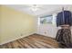Inviting bedroom features wood-look floors and a large window with backyard view at 5054 W 61St Dr, Arvada, CO 80003