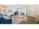 A bright living space featuring a blue couch, a glass table, a chair, and wood-look flooring under bright natural light at 5054 W 61St Dr, Arvada, CO 80003