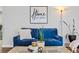 Comfortable blue couch in a well lit room with decorations, a plant, a decorative vase, and wood-look flooring at 5054 W 61St Dr, Arvada, CO 80003