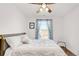 Bedroom with a window and a comfortable bed, illuminated by a modern ceiling fan at 4534 Nepal St, Denver, CO 80249