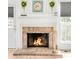Close-up of a cozy brick fireplace with a white mantel and decorative accents at 4534 Nepal St, Denver, CO 80249