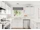Bright kitchen featuring white cabinetry, stainless steel appliances, and a window offering green outdoor views at 4534 Nepal St, Denver, CO 80249