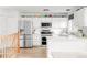 Modern kitchen with stainless steel appliances, white cabinetry, and hardwood floors with an open staircase at 4534 Nepal St, Denver, CO 80249