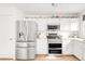 Well-lit kitchen with stainless steel appliances, white cabinetry, and a decorative shelf displaying colorful pitchers at 4534 Nepal St, Denver, CO 80249