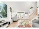 Spacious living room showcasing light wood floors, a large window, and a staircase at 4534 Nepal St, Denver, CO 80249