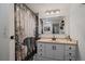 Bathroom with white vanity and drawers, shower with forest scene curtain, and framed mirror at 18902 E 17Th Ave, Aurora, CO 80011
