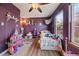 Whimsical purple bedroom with hardwood floors, a ceiling fan, and abundant natural light at 18902 E 17Th Ave, Aurora, CO 80011