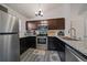 Well-lit kitchen with stainless steel appliances, modern dark cabinets, and granite countertops at 18902 E 17Th Ave, Aurora, CO 80011