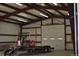 Well-lit garage interior featuring a trailer and other equipment; ideal for storage or workshop at 2981 Rock Cir, Elizabeth, CO 80107