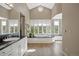 Bright bathroom featuring a soaking tub, large windows, granite countertop, and decorative plant at 315 Prospect Dr, Castle Rock, CO 80108