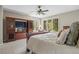 Spacious bedroom with wooden entertainment center, ceiling fan, and large windows showcasing wooded landscape at 315 Prospect Dr, Castle Rock, CO 80108
