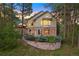 Lovely home with mature trees and stone retaining wall surrounded by lush landscaping at 315 Prospect Dr, Castle Rock, CO 80108