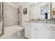 Bright bathroom featuring a tub-shower combo with tiled walls and a marble countertop vanity at 8331 Farmers Way, Highlands Ranch, CO 80129