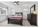 Bedroom with large window, carpet, ceiling fan, a full-sized bed, dresser, and lamps at 8331 Farmers Way, Highlands Ranch, CO 80129