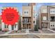 Beautiful three-story townhome featuring a stone accent wall and two balconies on the front of the home at 8331 Farmers Way, Highlands Ranch, CO 80129