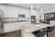 Modern kitchen featuring granite countertops, stainless steel appliances, and a sleek island with bar stools at 8331 Farmers Way, Highlands Ranch, CO 80129