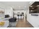 Open-concept living room flowing into kitchen, featuring a modern sectional sofa and hardwood floors at 8331 Farmers Way, Highlands Ranch, CO 80129