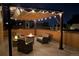 Cozy rooftop deck with a fire pit and comfortable seating under a pergola with string lights at 8331 Farmers Way, Highlands Ranch, CO 80129