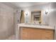 Well-lit bathroom showcases tile countertop, wooden cabinets, and a shower with colorful accents at 10978 W Ada Pl, Lakewood, CO 80226