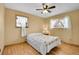 Bright bedroom with hardwood floors, two windows, and a simple yet cozy decor at 10978 W Ada Pl, Lakewood, CO 80226