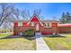 Attractive red two-story home with brick accents, landscaping, and sidewalk at 10978 W Ada Pl, Lakewood, CO 80226