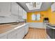 Bright kitchen with yellow walls, skylight, updated appliances, and tile flooring at 10978 W Ada Pl, Lakewood, CO 80226