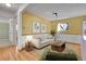 Cozy living room with hardwood floors, bright yellow walls, and comfortable furnishings at 10978 W Ada Pl, Lakewood, CO 80226