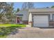 Charming home featuring a red front door, attached garage, and well-maintained lawn with an inviting appeal at 5190 S Emporia Way, Greenwood Village, CO 80111