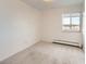 Carpeted bedroom with a window featuring blinds and baseboard heater along a wall at 5995 W Hampden Ave # 23, Denver, CO 80227