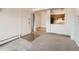 Open floor plan with carpet in the living room with an entrance door, leading to a kitchen with wood cabinets at 5995 W Hampden Ave # 23, Denver, CO 80227