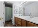 Bright bathroom with double sinks, wood cabinetry, and shower at 10519 Winterflower Way, Parker, CO 80134