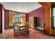 Dining room featuring a wooden table, burgundy walls, and a large window at 10519 Winterflower Way, Parker, CO 80134