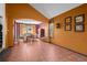 Open-concept living and dining area with tile floors, orange walls, and large windows at 10519 Winterflower Way, Parker, CO 80134