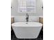 Close-up of a luxurious white soaking tub with black fixtures in a well-appointed bathroom at 1301 Sidewinder Cir, Castle Rock, CO 80108