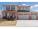 Two-story home boasts a three car garage, brick accents, neutral color, and well-manicured lawn at 1301 Sidewinder Cir, Castle Rock, CO 80108