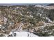 An aerial view showcases the property's expansive forested land and mountain setting at 4398 Cameyo Rd, Indian Hills, CO 80454