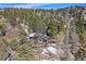 An aerial view of a luxurious mountain home with expansive decks surrounded by a dense forest landscape at 4398 Cameyo Rd, Indian Hills, CO 80454