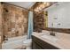 Rustic bathroom with decorative wood paneling, shower-tub combo and granite countertop sink at 4398 Cameyo Rd, Indian Hills, CO 80454