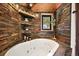 Relaxing bathroom features a soaking tub with stone accents and a view at 4398 Cameyo Rd, Indian Hills, CO 80454