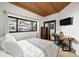 Cozy bedroom with desk, TV, natural light, and views of the snowy yard and trees at 4398 Cameyo Rd, Indian Hills, CO 80454
