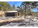 Charming stone home features an attached two-car garage and a welcoming entrance, complete with a stone walkway at 4398 Cameyo Rd, Indian Hills, CO 80454