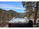 Outdoor hot tub with picturesque views of the surrounding mountains and forest at 4398 Cameyo Rd, Indian Hills, CO 80454