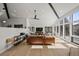 Bright living room boasts tall windows with mountain views, vaulted ceiling, hardwood floors and comfortable seating arrangement at 4398 Cameyo Rd, Indian Hills, CO 80454