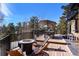 An inviting outdoor deck offers a dining table and seating around a fire pit, surrounded by lush trees at 4398 Cameyo Rd, Indian Hills, CO 80454