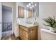 Bathroom featuring a single sink vanity with light wood cabinets, and modern lighting fixtures at 5511 S Lowell Blvd, Littleton, CO 80123