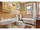 Well-lit bathroom with clawfoot tub, pedestal sink, and wainscotting at 1345 N Franklin St, Denver, CO 80218