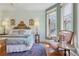 Bright bedroom boasts natural light, wood floors, ornate headboard and seating area at 1345 N Franklin St, Denver, CO 80218