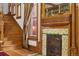 Elegant living space showcases a fireplace with ornate wood mantel and tiled surround, adjacent to a wooden staircase at 1345 N Franklin St, Denver, CO 80218