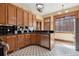 Well-lit kitchen with wood cabinets, black countertops, and black-and-white tile flooring at 1345 N Franklin St, Denver, CO 80218